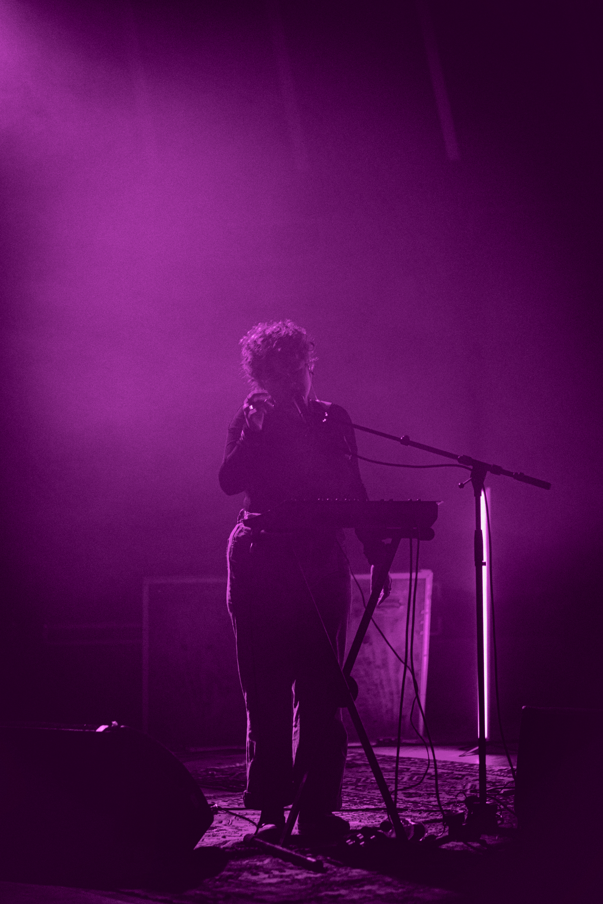 Nicoline Andrea performing live on a pink-lit stage